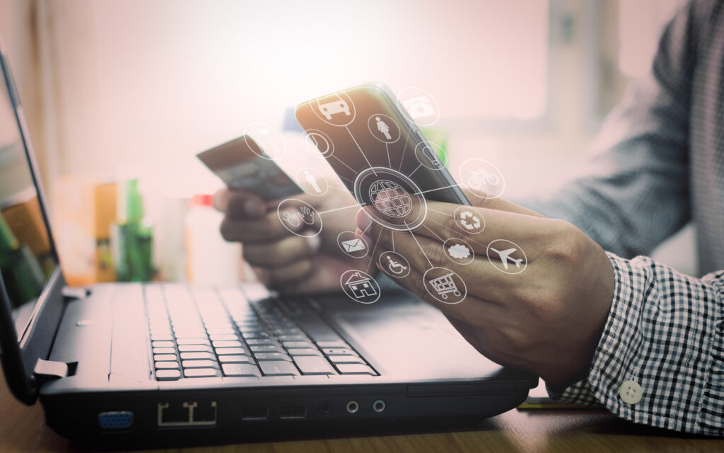 Businessman using laptop and mobile phone to online shopping and pay by credit card with virtual graphic icon diagram.